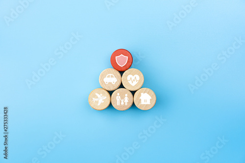 Insurance concept. Wooden blocks with insurance icons. family, life, car, travel, health and house insurance icons. blue background with copy space, minimal