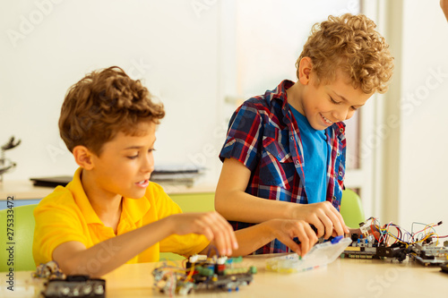 Happy positive boys constructing different toys together