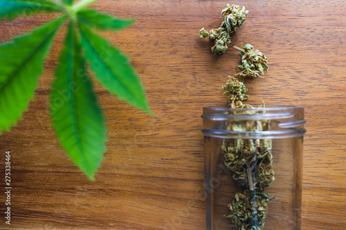 A glass Jar of Medical Marijuana on a wooden table