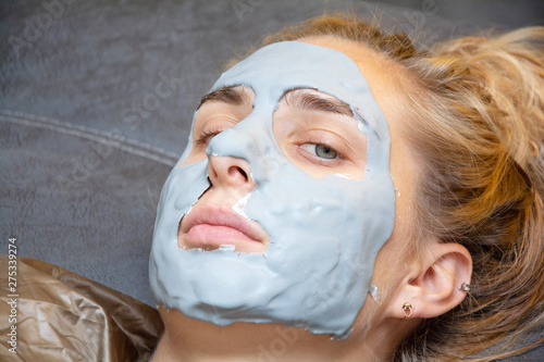 Spa Woman applying Facial clay Mask. Beauty Treatments.facial cleansing, cosmetology, beauty mask