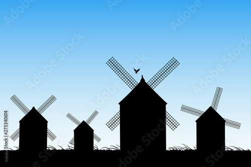 Windmills in field. Vector illustration with silhouettes of mills. Summer rural landscape. Blue pastel background