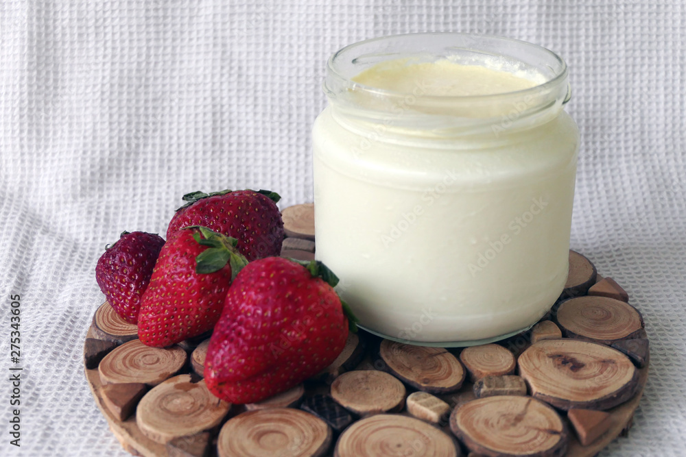 Homemade Yoghurt in a Jar with Strawberries on a Wooden Board Homemade Yoghurt in a Jar with Strawberries on a Wooden Board
