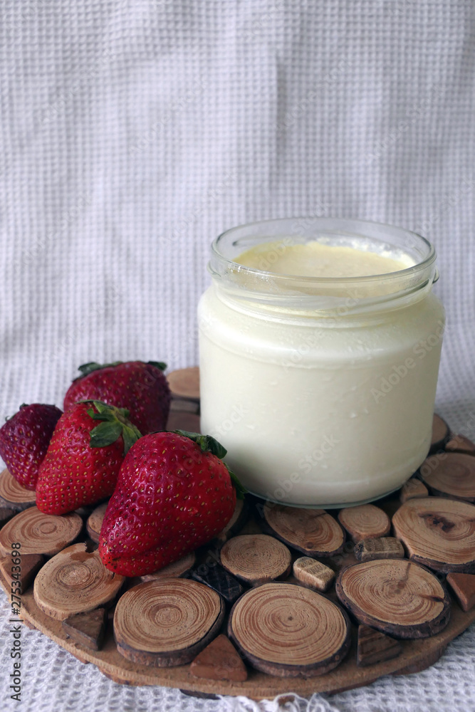 Homemade Yoghurt in a Jar with Strawberries on a Wooden Board Homemade Yoghurt in a Jar with Strawberries on a Wooden Board