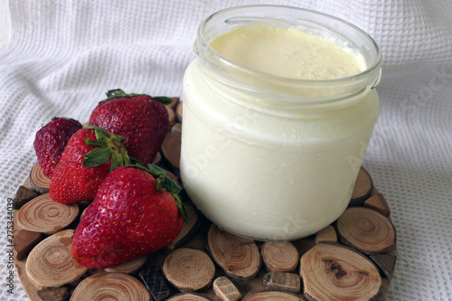 Homemade Yoghurt in a Jar with Strawberries on a Wooden Board