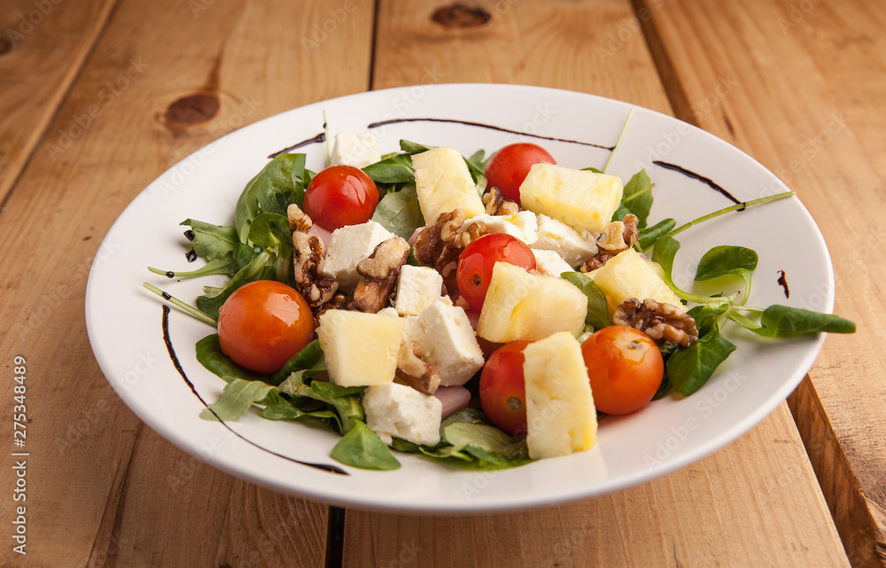 Healthy pineapple , tomato cherry , nuts and canons salad .