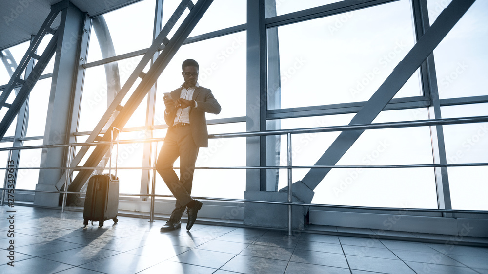 Young Businessman Waiting for Flight, Standing in Airport Terminal Young Businessman Waiting for Flight, Standing in Airport Terminal