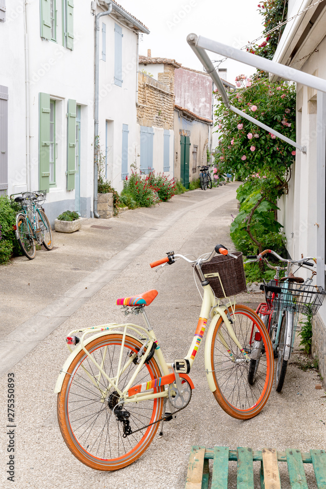 street in Ile de Re with white house green shutter and beach cruiser bike street in Ile de Re with white house green shutter and beach cruiser bike