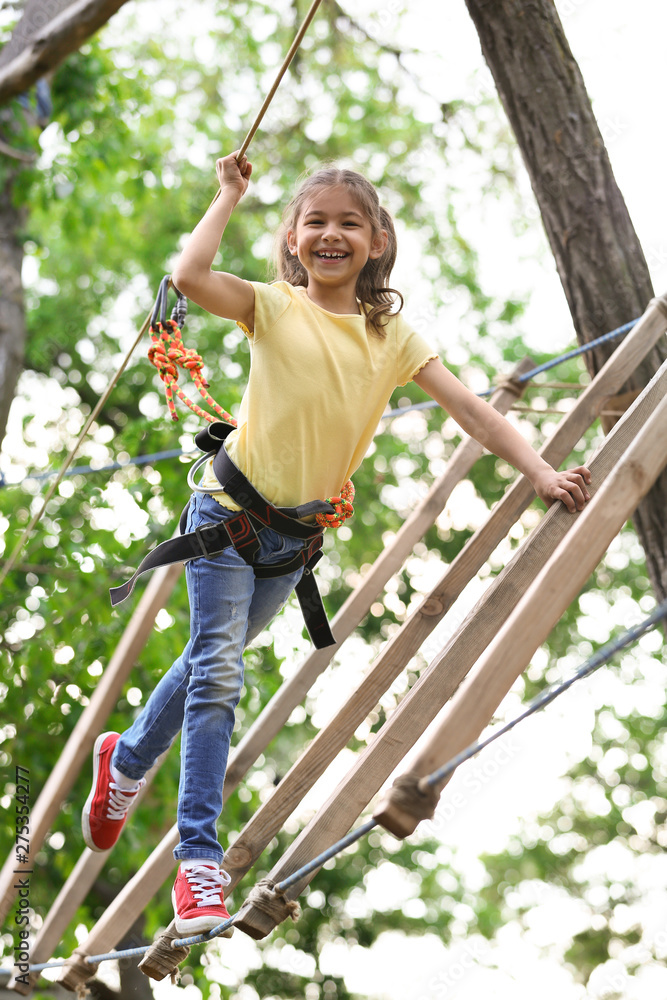Little girl climbing in adventure park. Summer camp Little girl climbing in adventure park. Summer camp