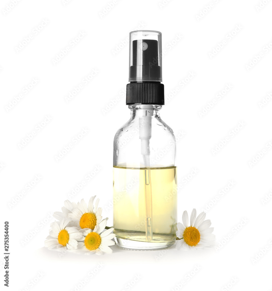 Bottle of herbal essential oil and chamomile flowers isolated on white Bottle of herbal essential oil and chamomile flowers isolated on white