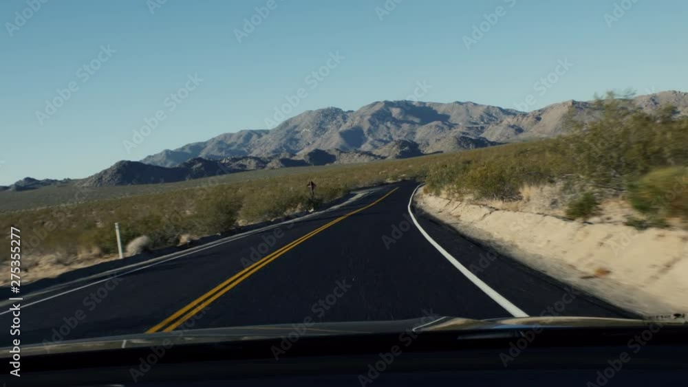 A HANDHELD SHOT driving through a desert, looking out of a windscreen with mountains in the background. Southwest USA. A HANDHELD SHOT driving through a desert, looking out of a windscreen with mountains in the background. Southwest USA.