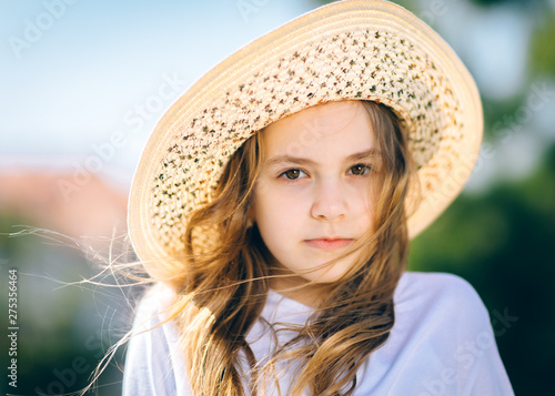 portrait of a young girl with a hat on sunny day