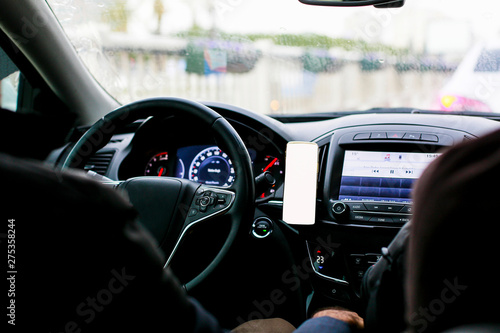 Inside view of the car and mobile phone by the steering wheel