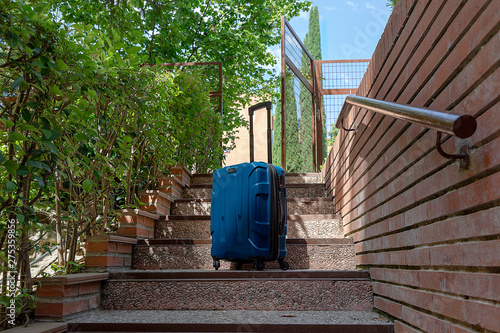 Suitcase on the stairs of a garden photo