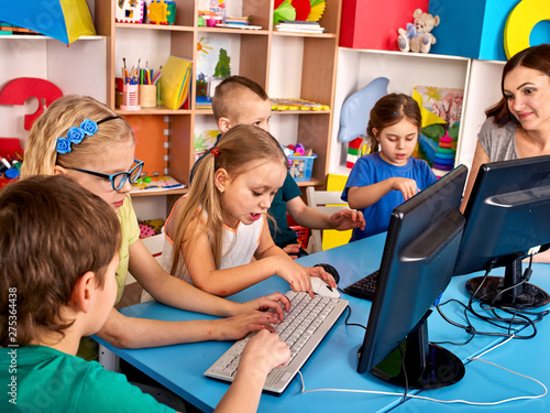 Computer education for children use computer game in class with teacher.