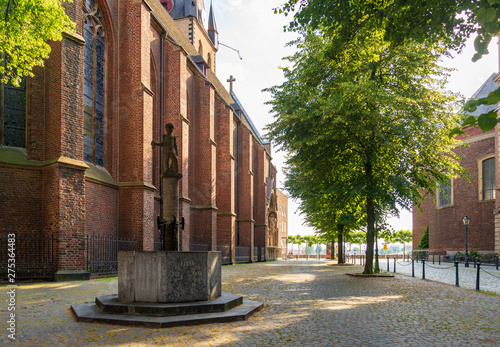 Outdoor sunny and shady tranquil scenery of Stiftsplatz and St. Lambertus Church in old town Düsseldorf, Germany. Historical old brick church with shady and silence atmosphere in Düsseldorf, Germany.