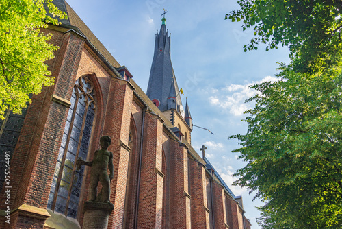 Outdoor sunny and shady tranquil scenery of Stiftsplatz and St. Lambertus Church in old town Düsseldorf, Germany. Historical old brick church with  shady and silence atmosphere in Düsseldorf, Germany. photo