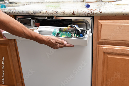 Fotografija Closeup of a appliance repairman removing the control panel to a broken dishwash