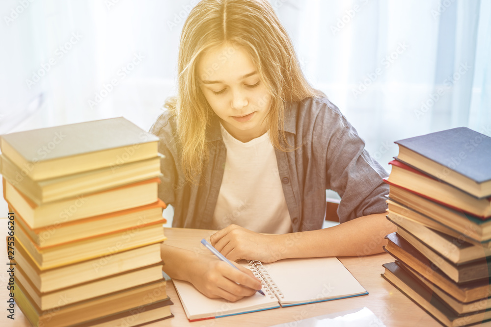 Young student sitting at desk in home studying and reading, doing homework and lesson practice preparing exam to entrance, education concept. Young student sitting at desk in home studying and reading, doing homework and lesson practice preparing exam to entrance, education concept.