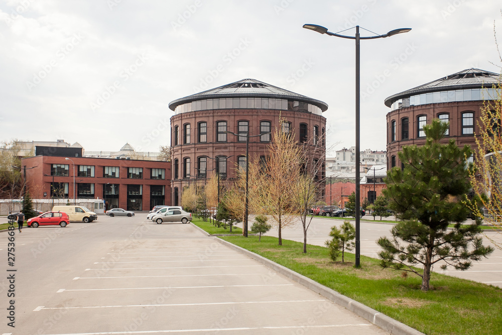 Decorative lighting pole in cityscape. Modern loft building from red brick in downtown area. Manufacture Arma in Moscow. Industrial design in city architecture. Business concept.