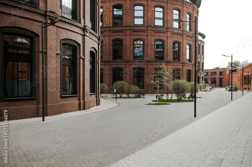 Decorative lighting pole in cityscape. Modern loft building from red brick in downtown area. Manufacture Arma in Moscow. Industrial design in city architecture. Business concept.