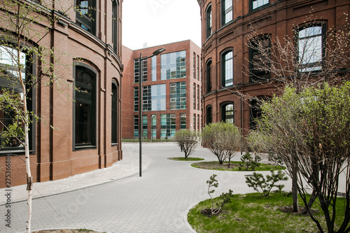 Decorative lighting pole in cityscape. Modern loft building from red brick in downtown area. Manufacture Arma in Moscow. Industrial design in city architecture. Business concept.