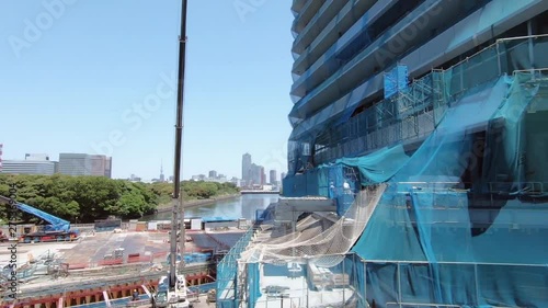 Japanese railway car window. Construction site and urban landscape