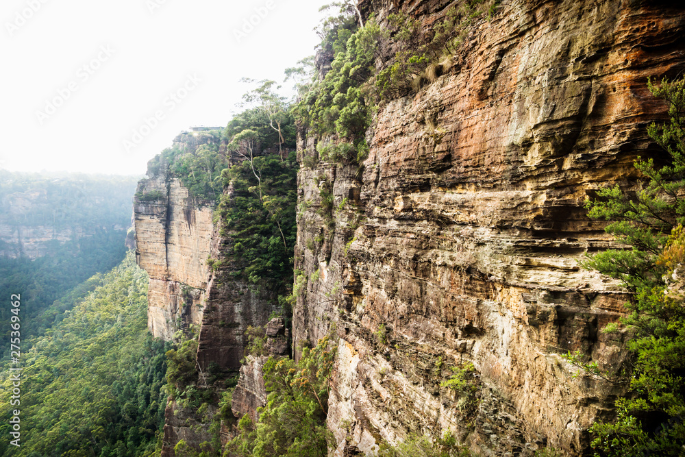 Fototapeta premium Long cliffs and canyons along the Three Sisters with view to Echo Point with backlight, Katoomba, New South Wales, Australia