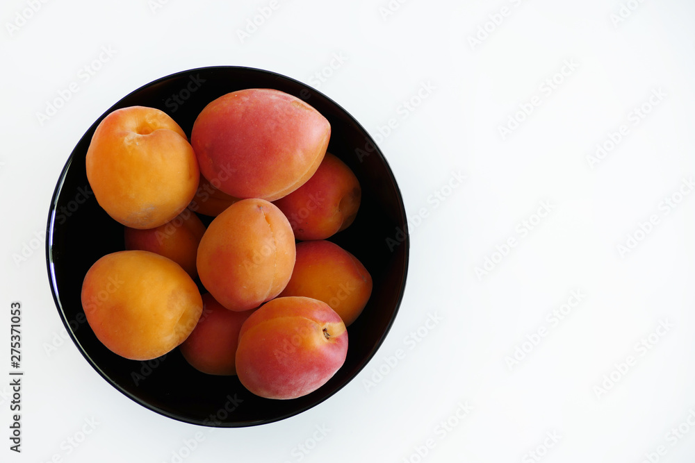 Apricots in a Black Bowl isolated on a White Background Apricots in a Black Bowl isolated on a White Background