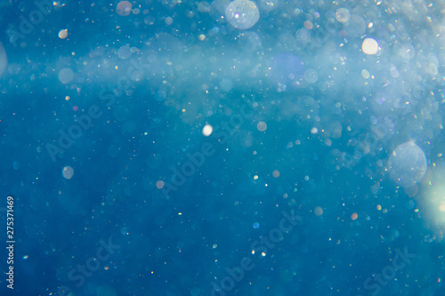 sunny blue underwater background with particles photo