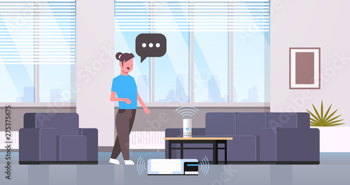 housewife using smart speaker voice recognition controlling vacuum cleaner housework concept modern living room interior flat horizontal full length