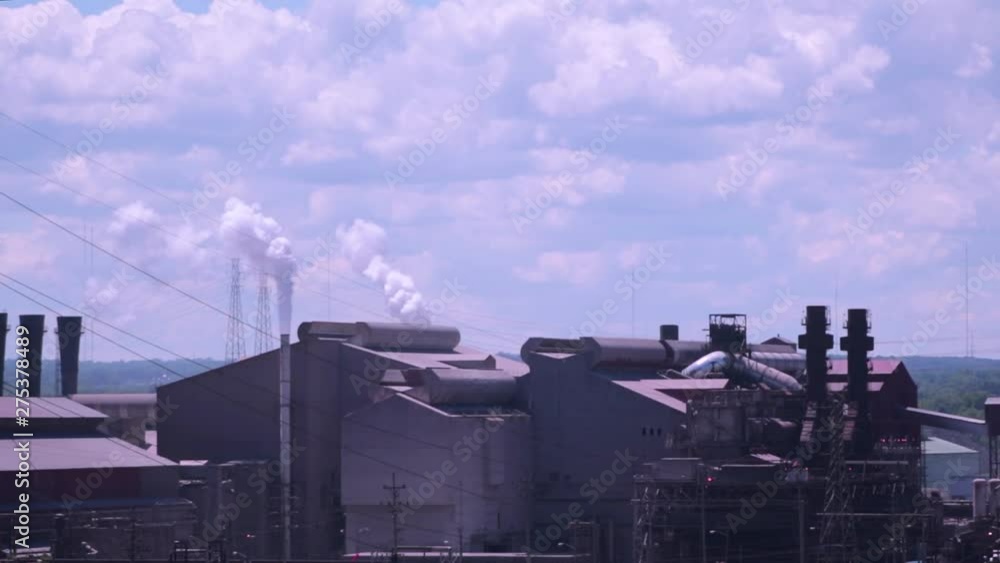 Factories producing pollution in the air on a sunny day with blue skies