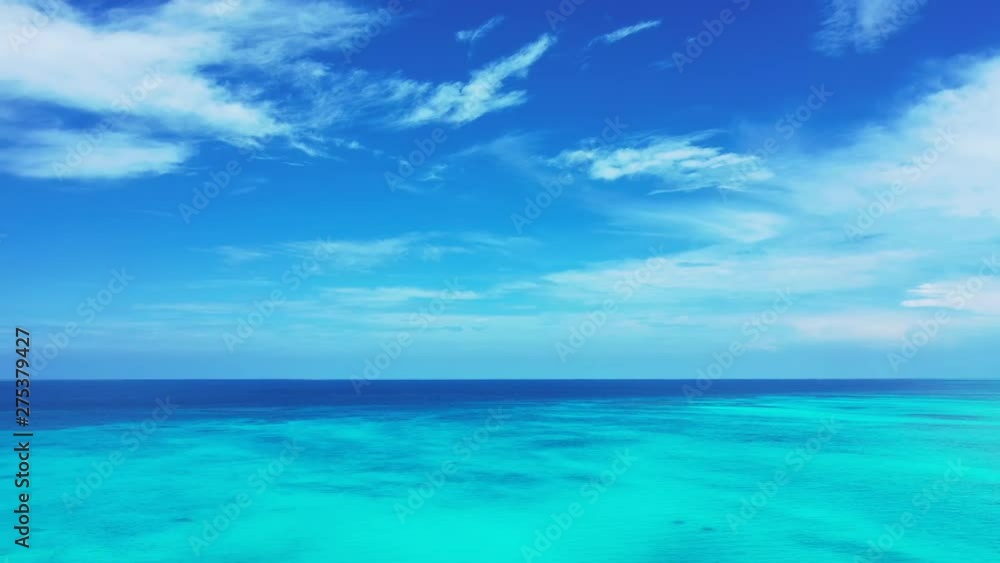Drone flying over a vast endless expanse of turquoise waters in Thailand. Blue sky with scattered clouds above Drone flying over a vast endless expanse of turquoise waters in Thailand. Blue sky with scattered clouds above