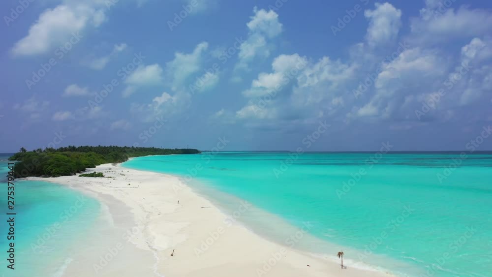 Front view of a long stretch of white sand beach on an island in the Caribbean, surrounded by turquoise waters