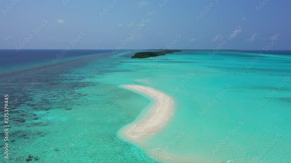 Drone flying over a small white sand beach island off the coast of a tropical island on the reef in the Maldives Drone flying over a small white sand beach island off the coast of a tropical island on the reef in the Maldives