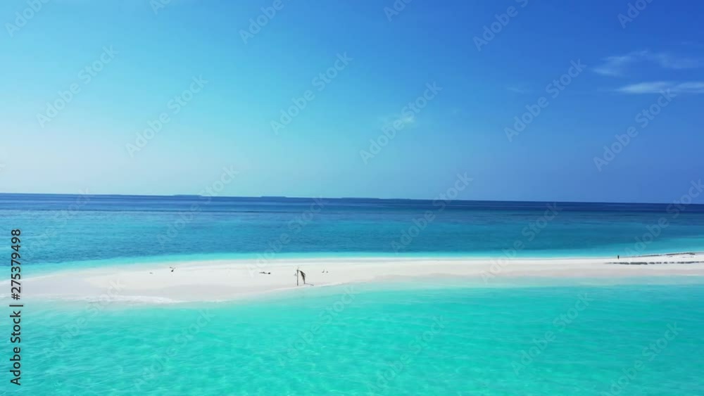 Drone flying around a white sand stretch of beach surrounded by turquoise waters in Thailand. No tourists are visible on the beach Drone flying around a white sand stretch of beach surrounded by turquoise waters in Thailand. No tourists are visible on the beach