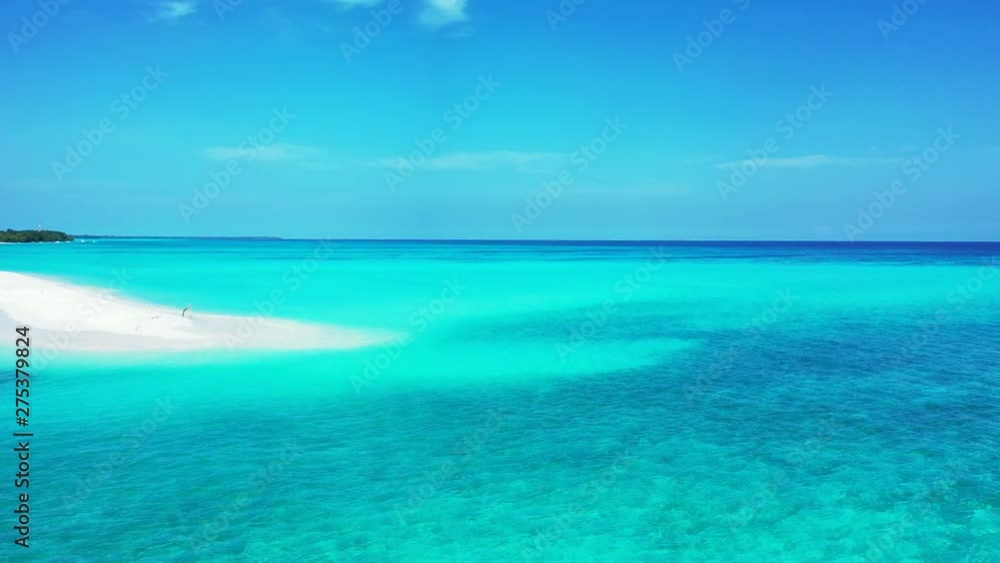 An elongated strip of white sand extending into the deep azure waters of ocean in the Caribbean, with no people visible on the beach An elongated strip of white sand extending into the deep azure waters of ocean in the Caribbean, with no people visible on the beach
