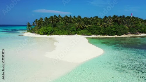 Drone flying above a white sand stretch of beach in a tropical island in the Indian Ocean, Maldives photo