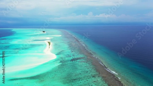 drone footage of a big area of the coral reef in the Caribbean with many white sandy islands with some green bushes photo