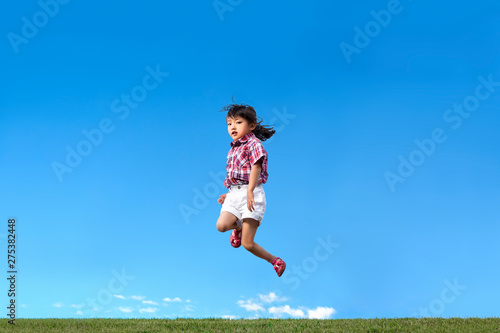 青空を背景にジャンプする幼児。希望、幸せ、飛躍、未来イメージ © chikala