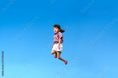 青空を背景にジャンプする幼児。希望、幸せ、飛躍、未来イメージ
