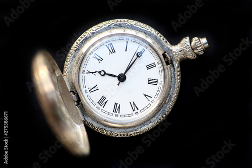 Close up pocket watch on black background