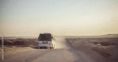 Bus and truck passing through the dusted roads in Mines and quarries