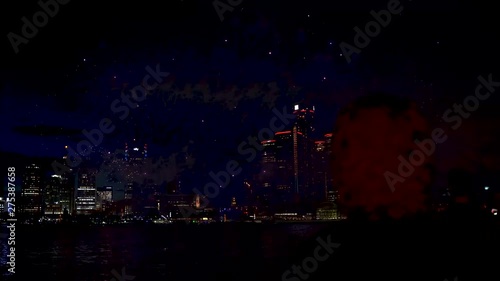 Fireworks going off over the Detroit river with a male on looker in the foreground.