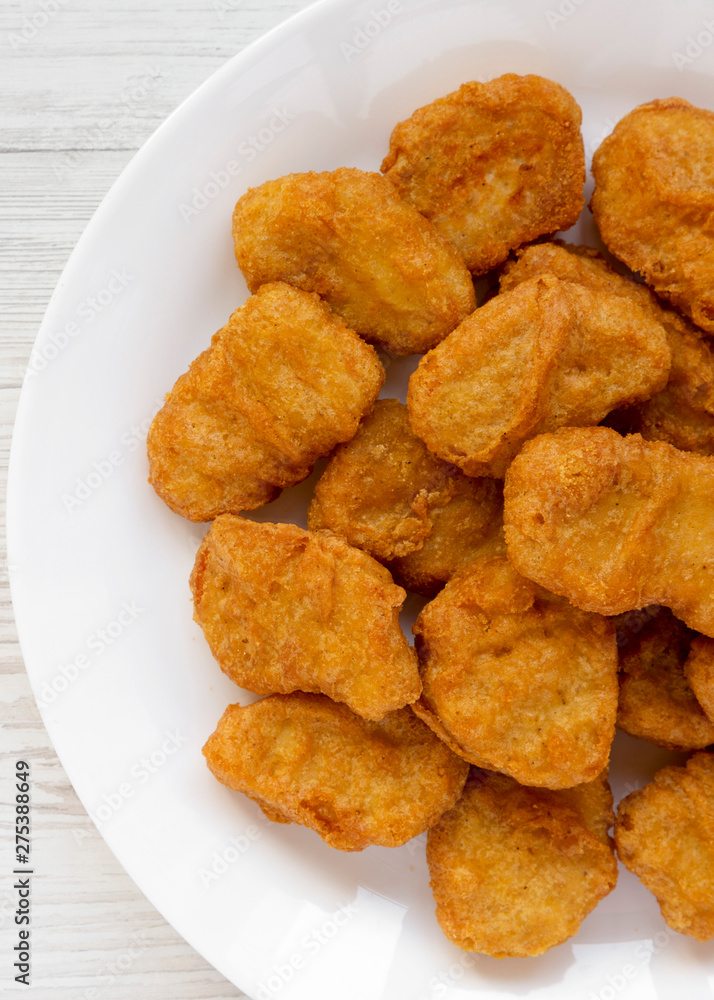 Chicken nuggets on a plate on a white wooden background, top view. Overhead, from above, flat lay. Close-up. Chicken nuggets on a plate on a white wooden background, top view. Overhead, from above, flat lay. Close-up.
