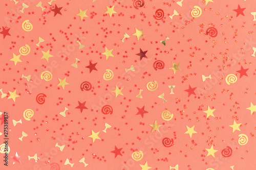 Bright red and gold festive confetti with swirls and wine flutes on trendy coral background. flat lay border backdrop for party birthday celebration or greeting card copy space