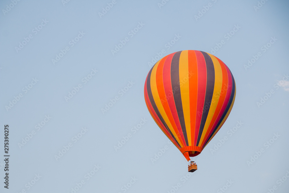 Colorful hot air balloon moving up in blue sky. Colorful hot air balloon moving up in blue sky.