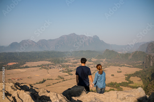 Back view of a couple watching view at Pha Nguen mountain in Vangvieng, Laos