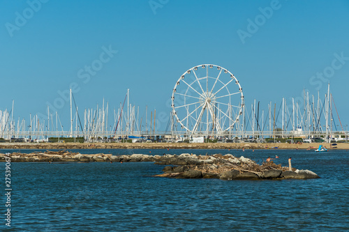 A Beautiful Small Promontory and a Ferris Wheel Standing near an Italian Beach
