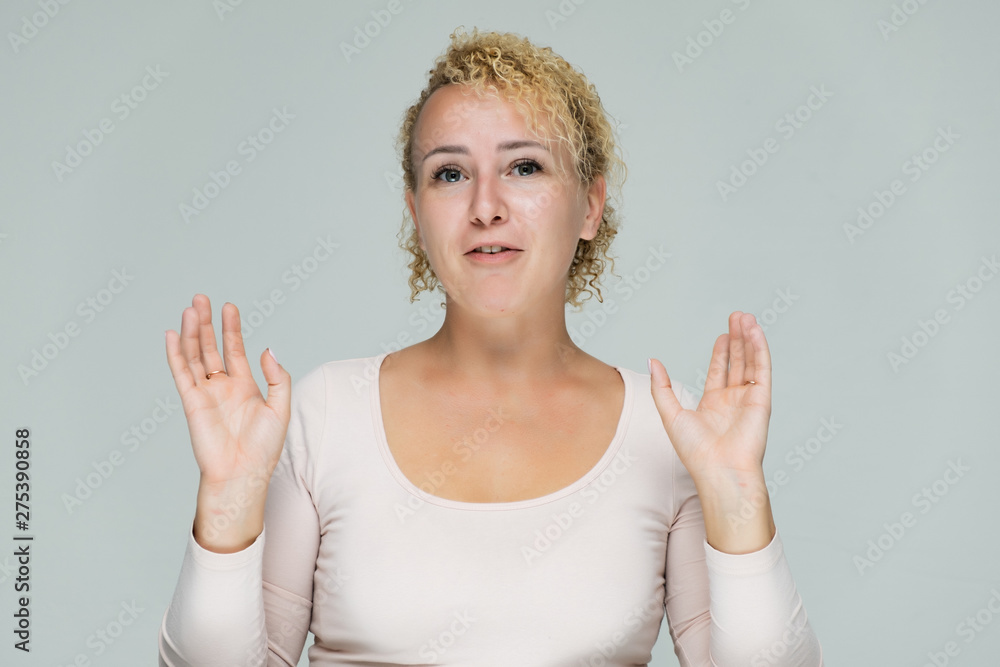 Photo portrait of a beautiful girl blonde woman with short curly hair on a white background talking and showing a lot of emotions. An experienced model shows hands. Beauty. Photo portrait of a beautiful girl blonde woman with short curly hair on a white background talking and showing a lot of emotions. An experienced model shows hands. Beauty.