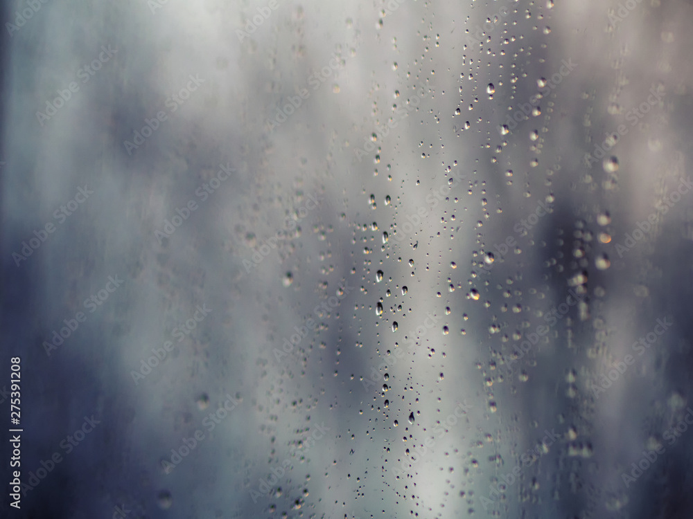 ..Raindrops on the surface of window glass with a blurred background.